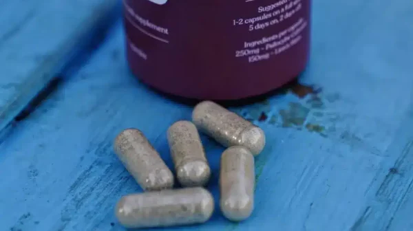 Psilocybin Capsules and bottle on blue wood deck